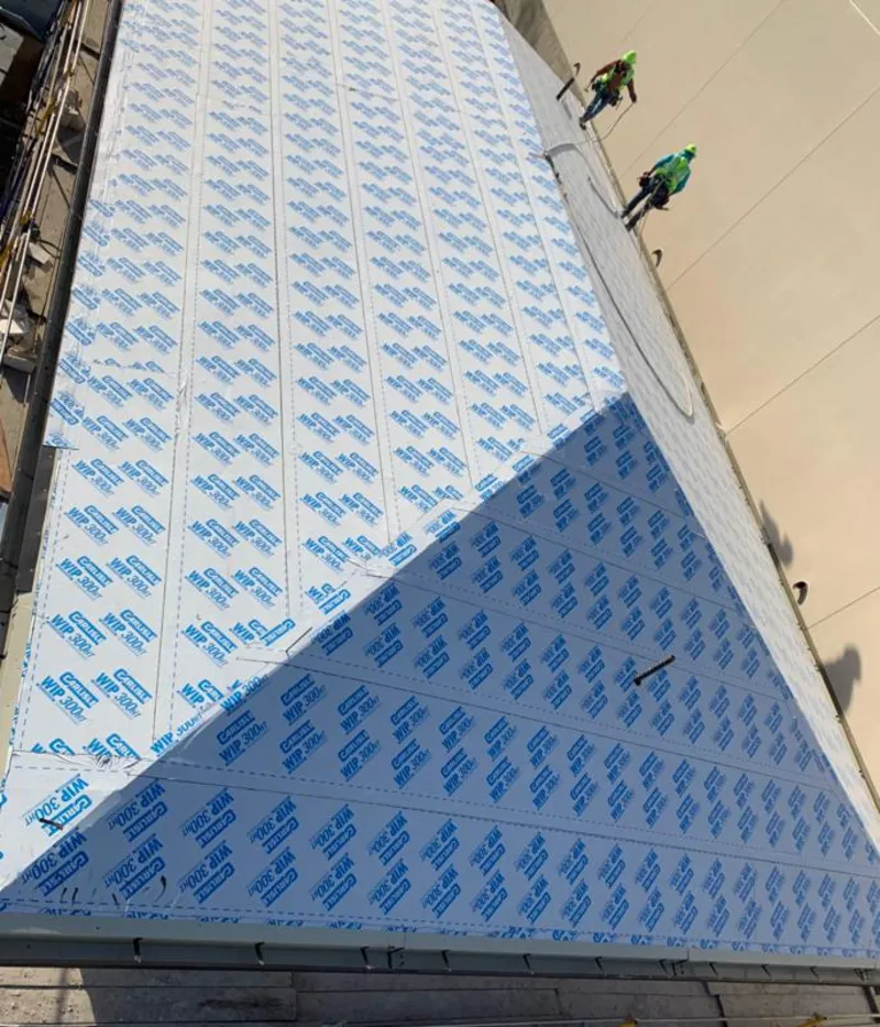 Professional roofers installing underlayment on a metal roof in West Whiteland